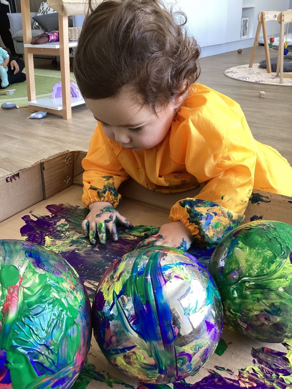 Children exploring paint and materials through curiosity-driven learning