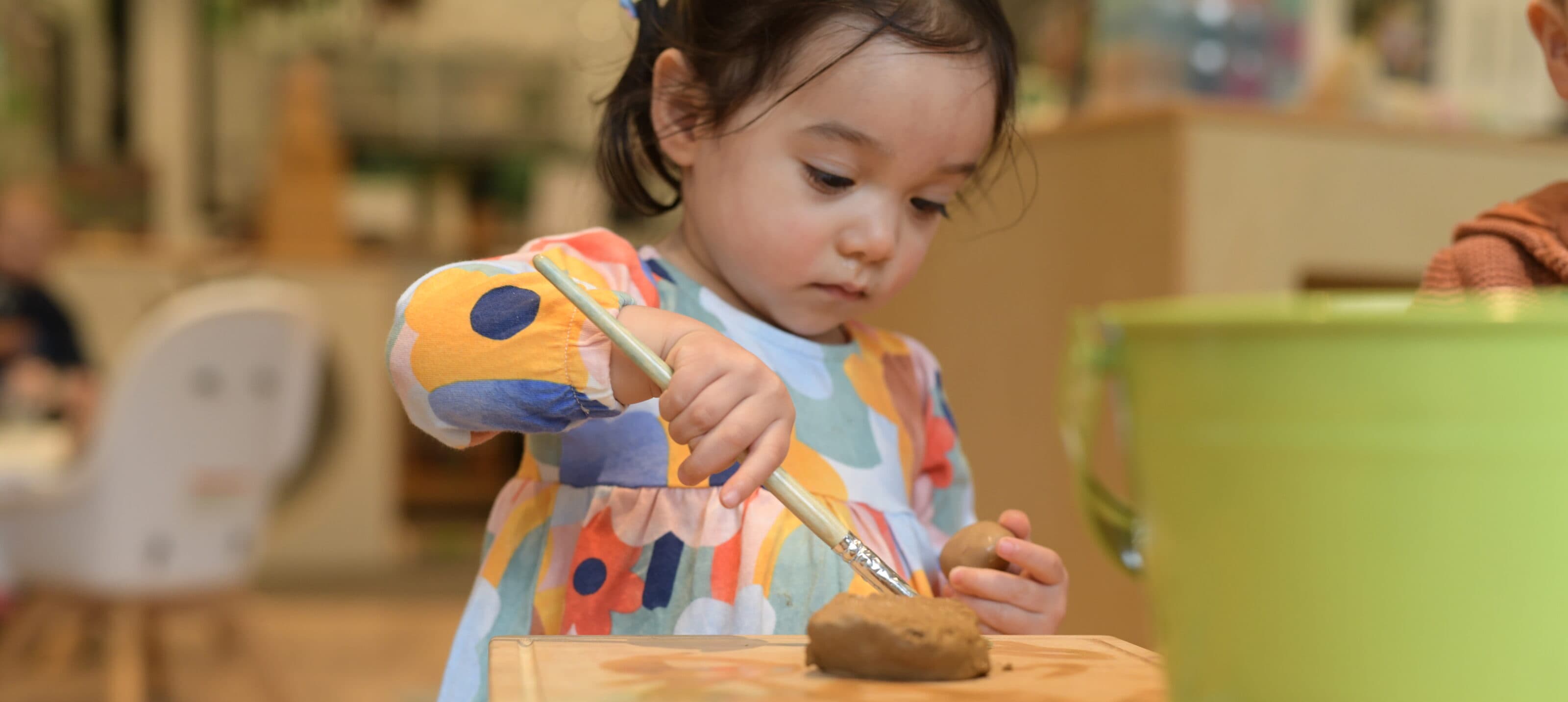 child playing with clay at the centre explorers