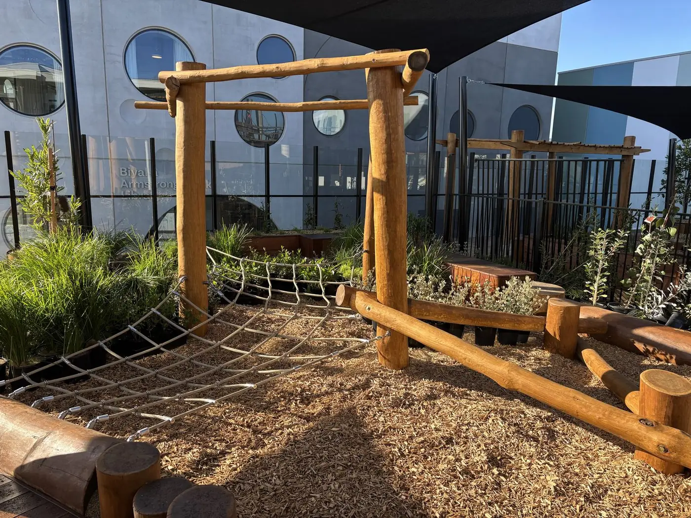 Natural timber climbing structure with a rope net in the Armstrong Creek outdoor environment